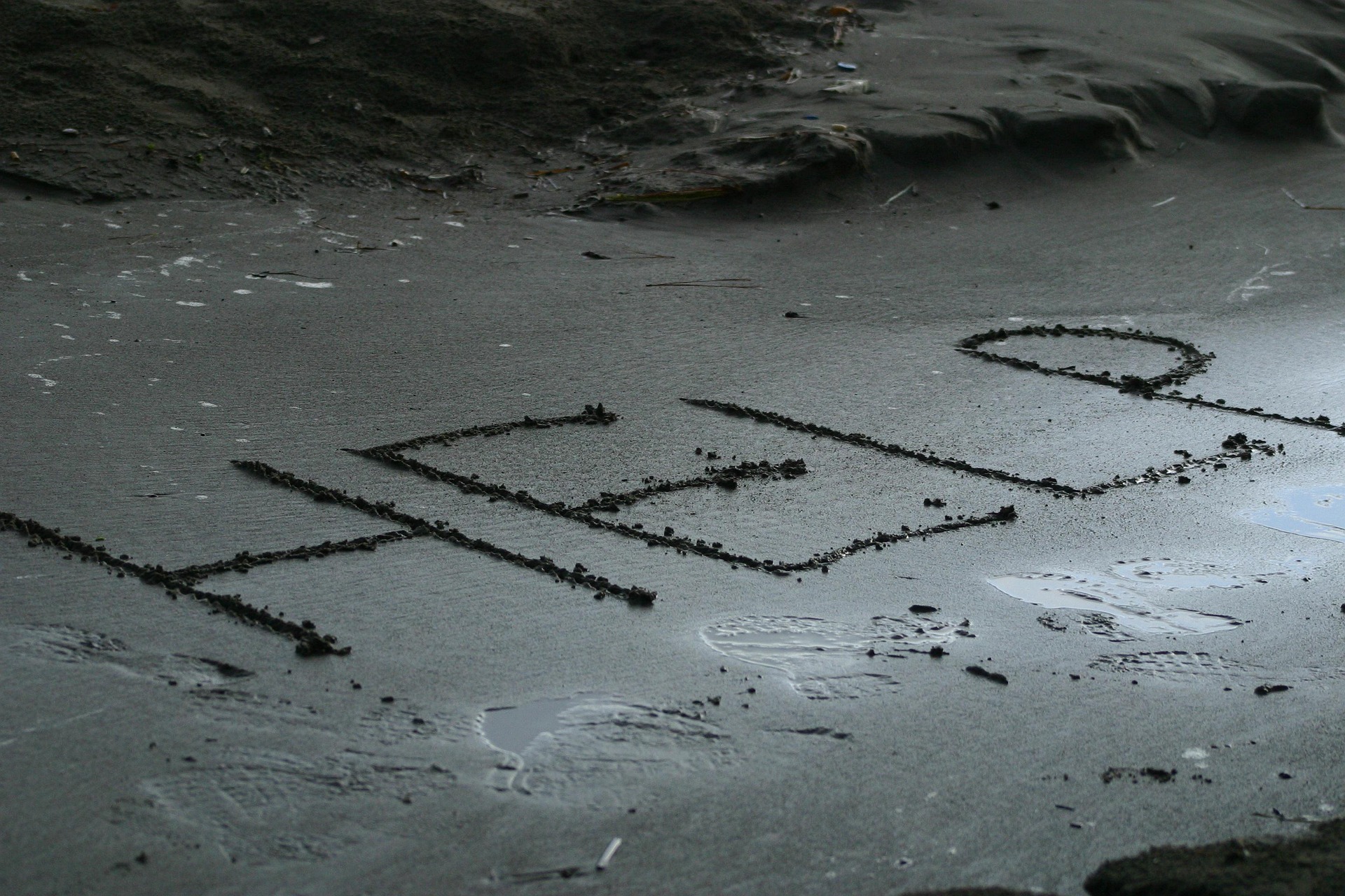 Message on a beach that says H E L P